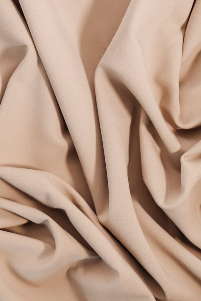 Close-up of beige cloth showcasing texture and folds, perfect for textile and design projects.